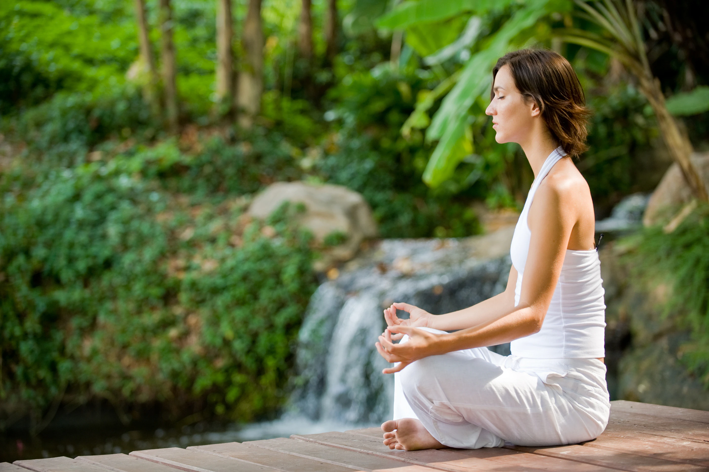 A young woman practicing yoga outside in nature
