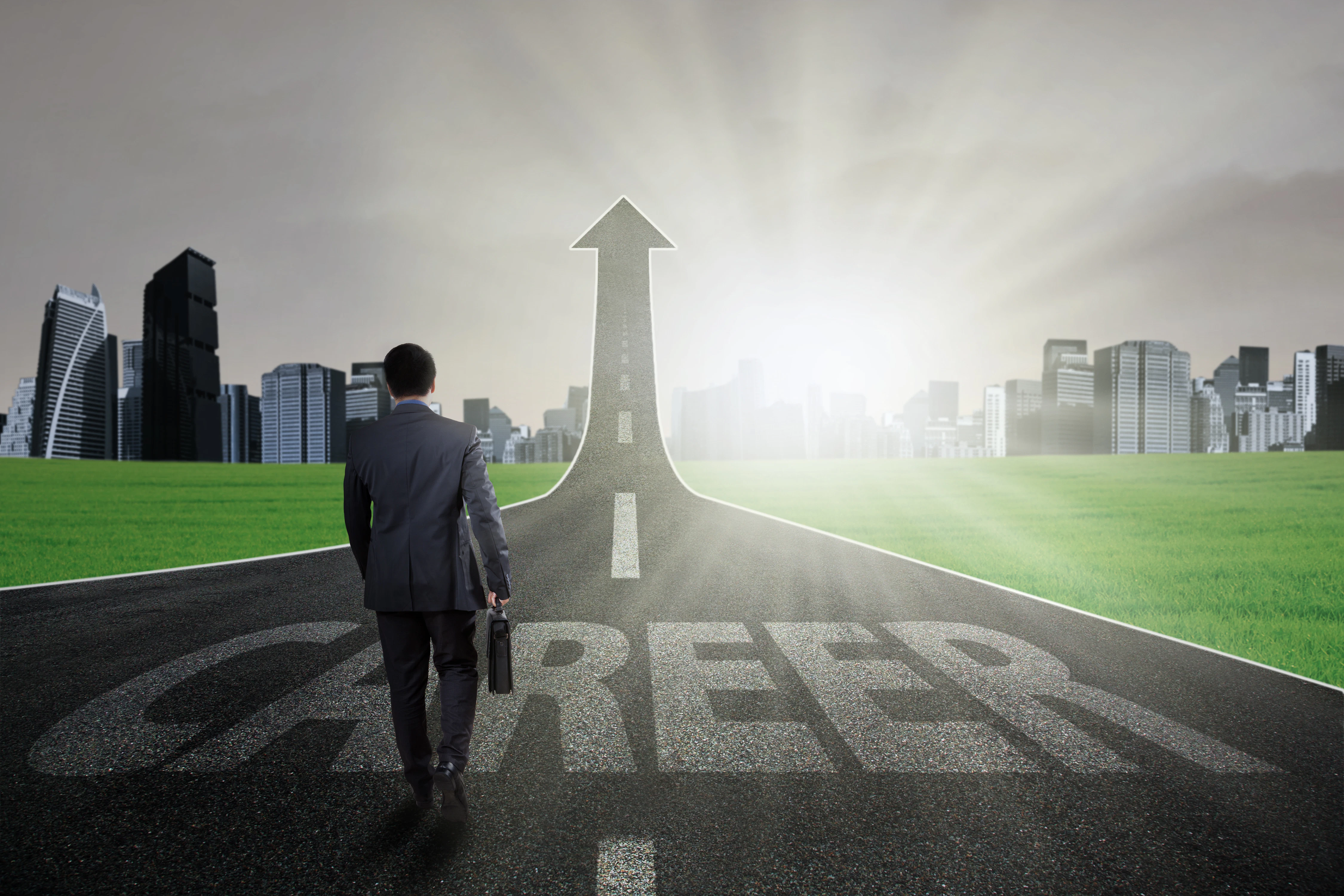 Young businessman carry a briefcase and walk on the path with a career text going up as an arrow